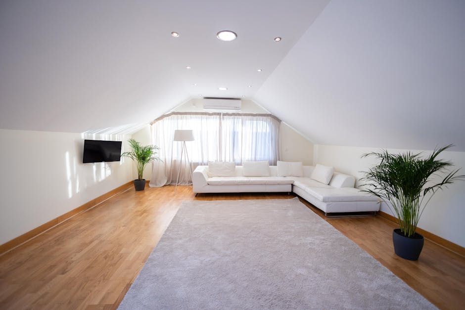 A spacious living room with a beige carpeted floor that appears clean and well-maintained. The room features cream-colored walls with a decorative section painted in a contrasting reddish-brown color,